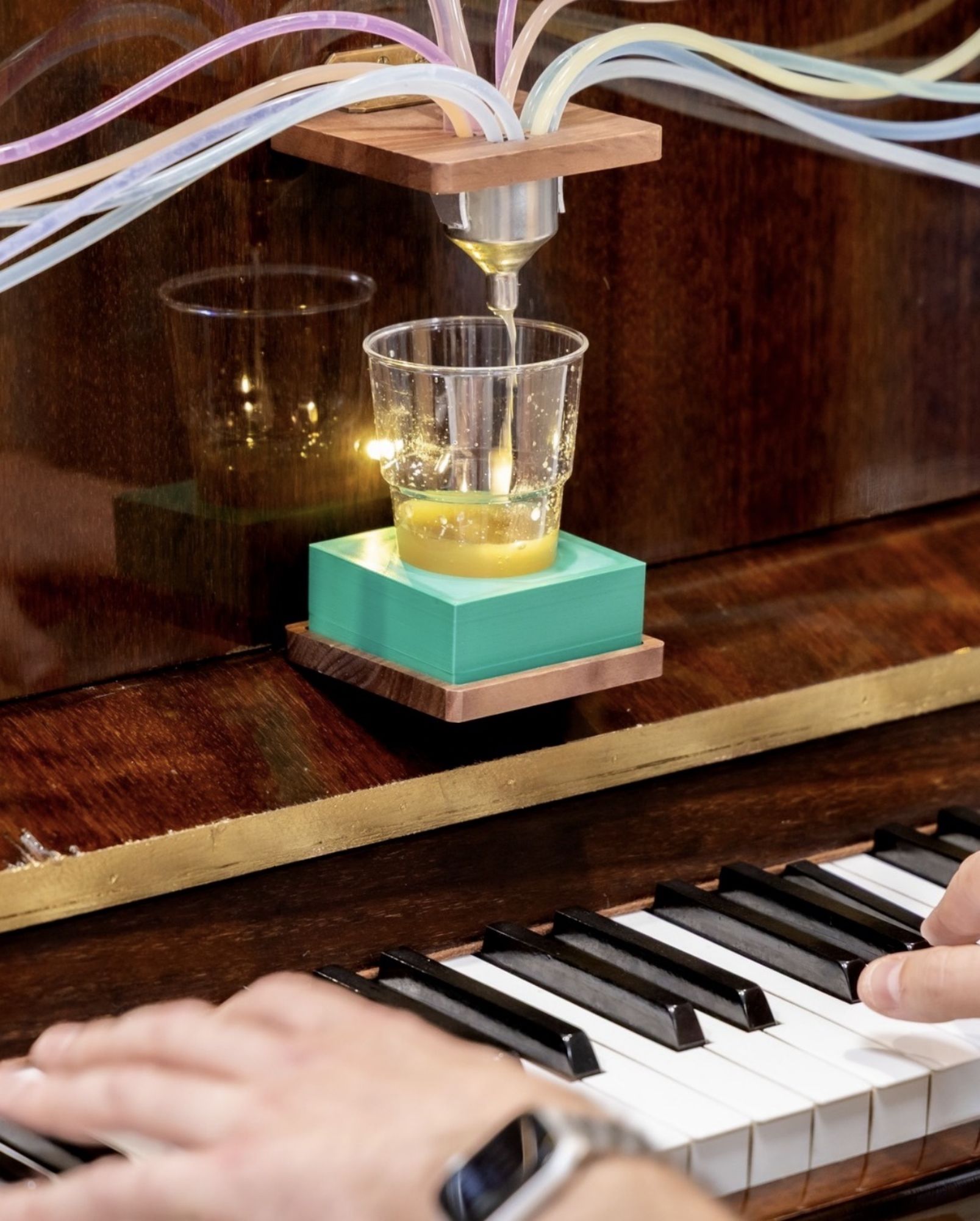 Le verre se remplit sous les tubes du Pianocktail pendant que le clavier est joué