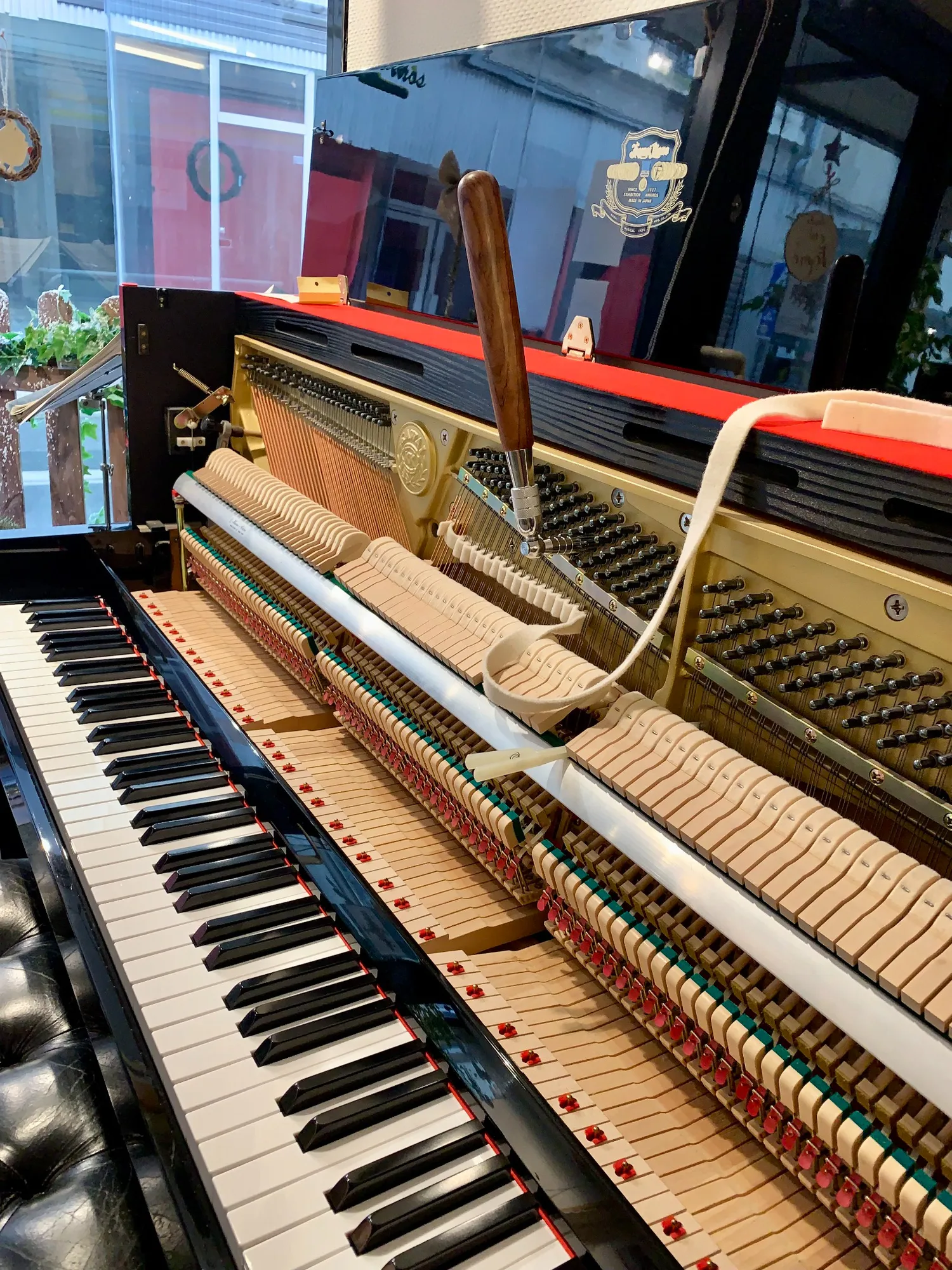 Accord d’un piano droit ouvert, avec la clé d’accord placée sur les chevilles