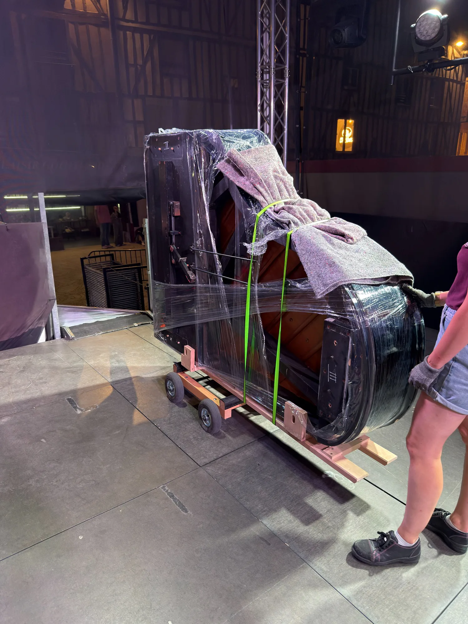Piano à queue protégé et installé sur la tranche pendant sa mise en place sur scène