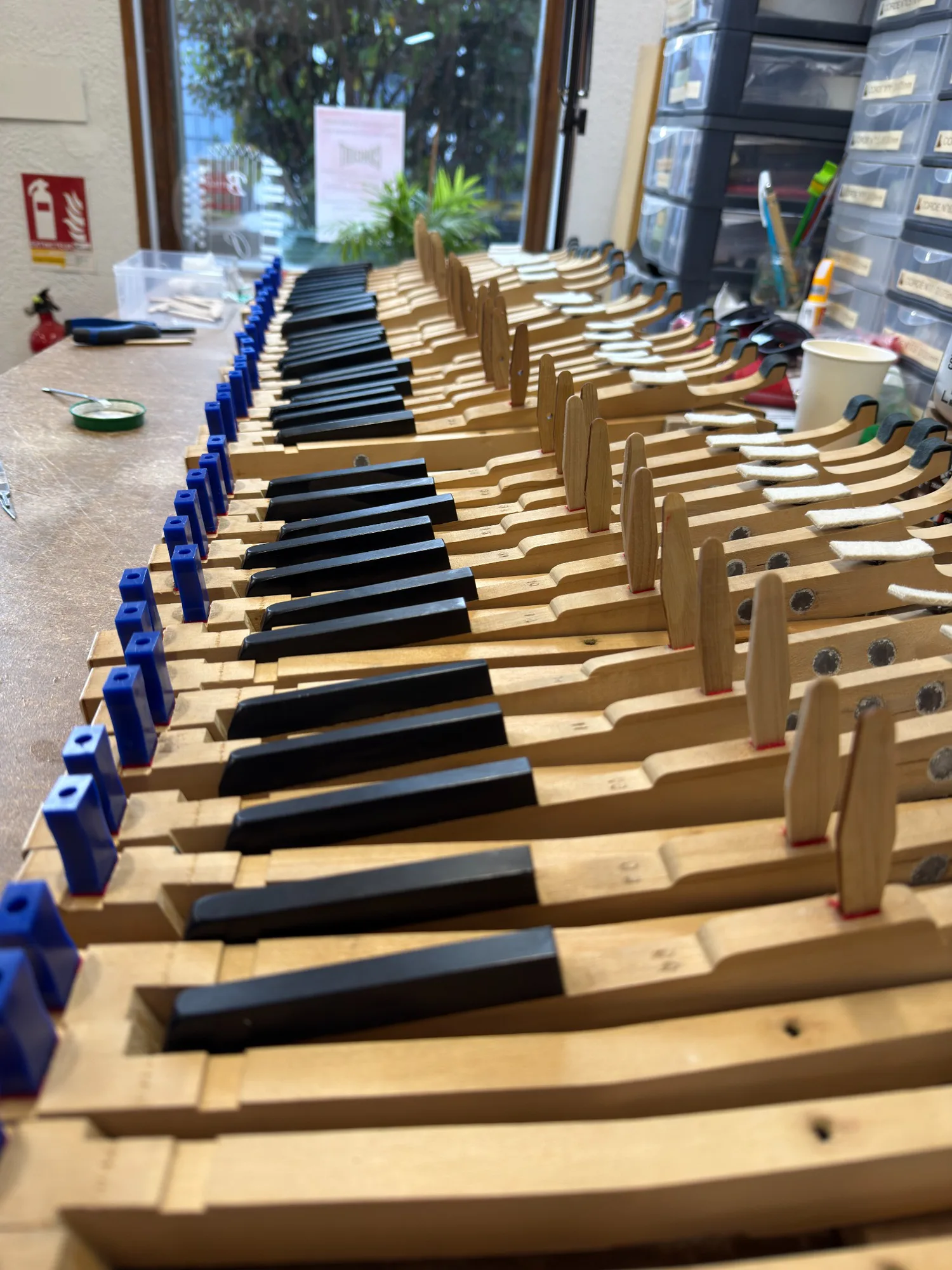 Ensemble des touches d’un piano déposé sur l’établi pendant sa restauration